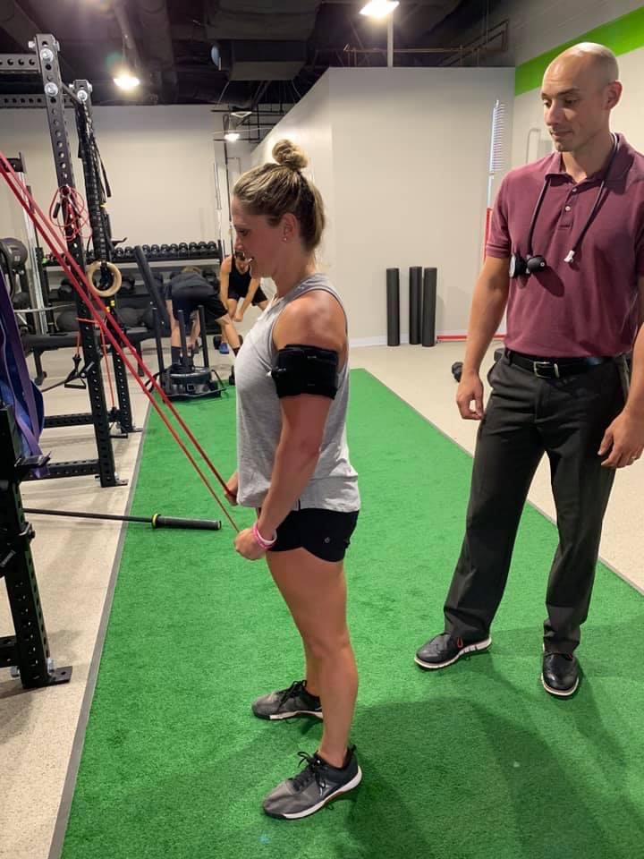 Dr. Jon Coulson assists a patient with a physical therapy exercise to provide healing and recovery at PRIME Physical Therapy.