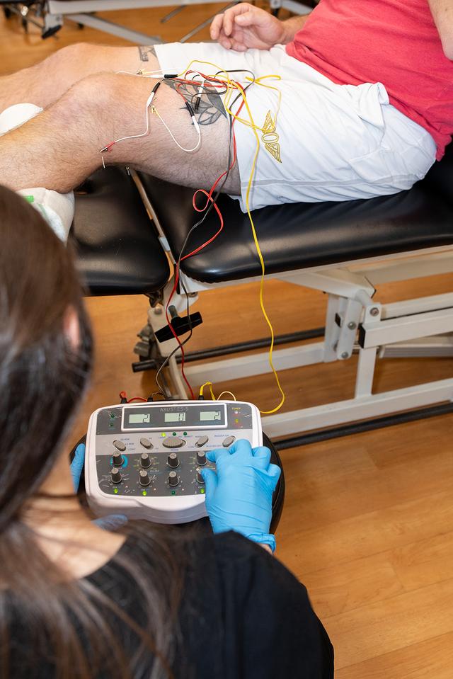 Dr. Jon Coulson ensures a patient's proper form during an exercise at PRIME Physical Therapy clinic.