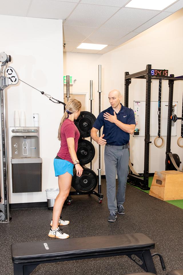 Personal trainer Bryan Trumbo poses and smiles with two of his fitness clients at PRIME Physical Therapy in Eldersburg, Maryland.